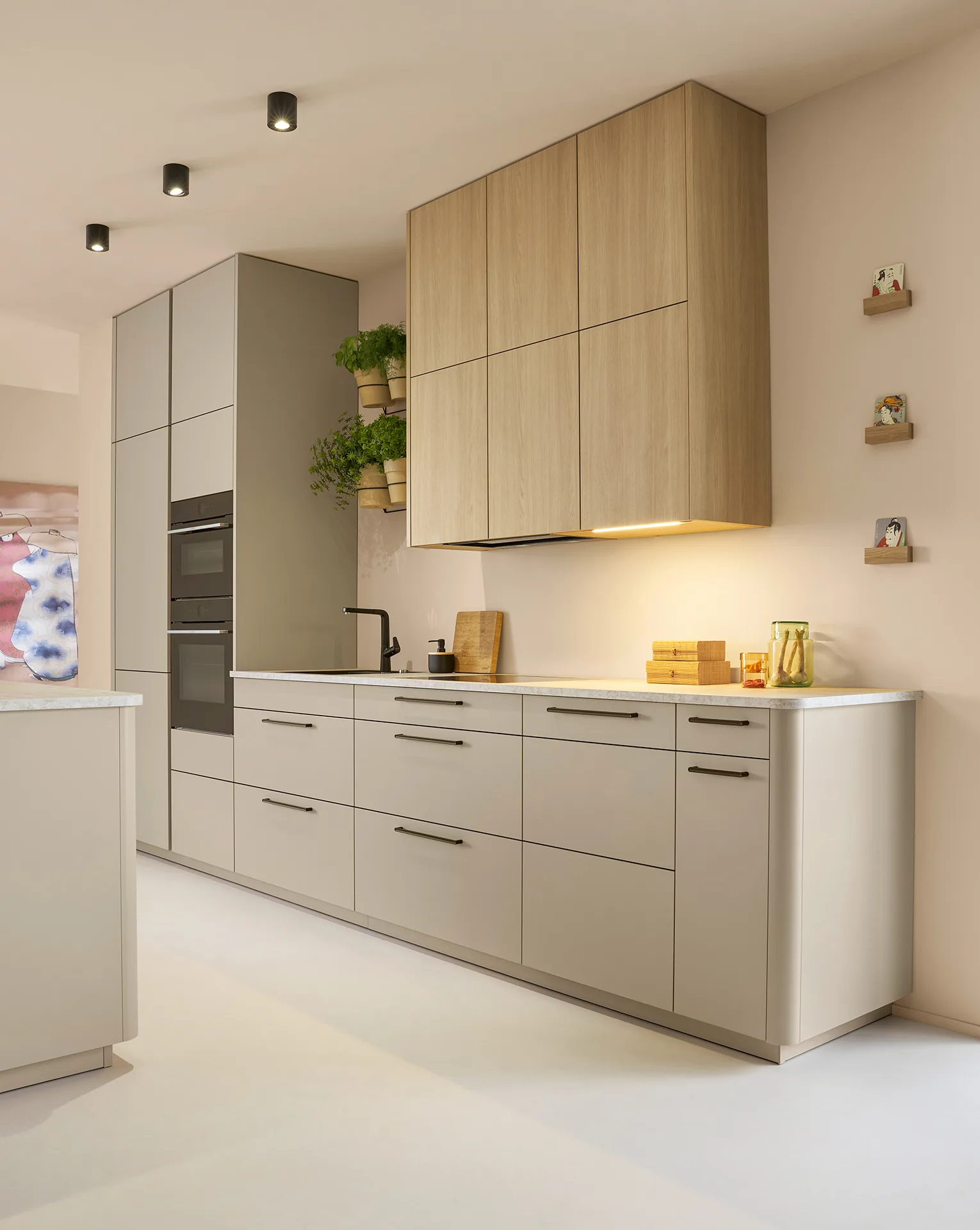 Küchenzeile in Beige-Hochglanz mit Eiche-Dunstabzugshaube und Marmoroptik — Miller Küchen