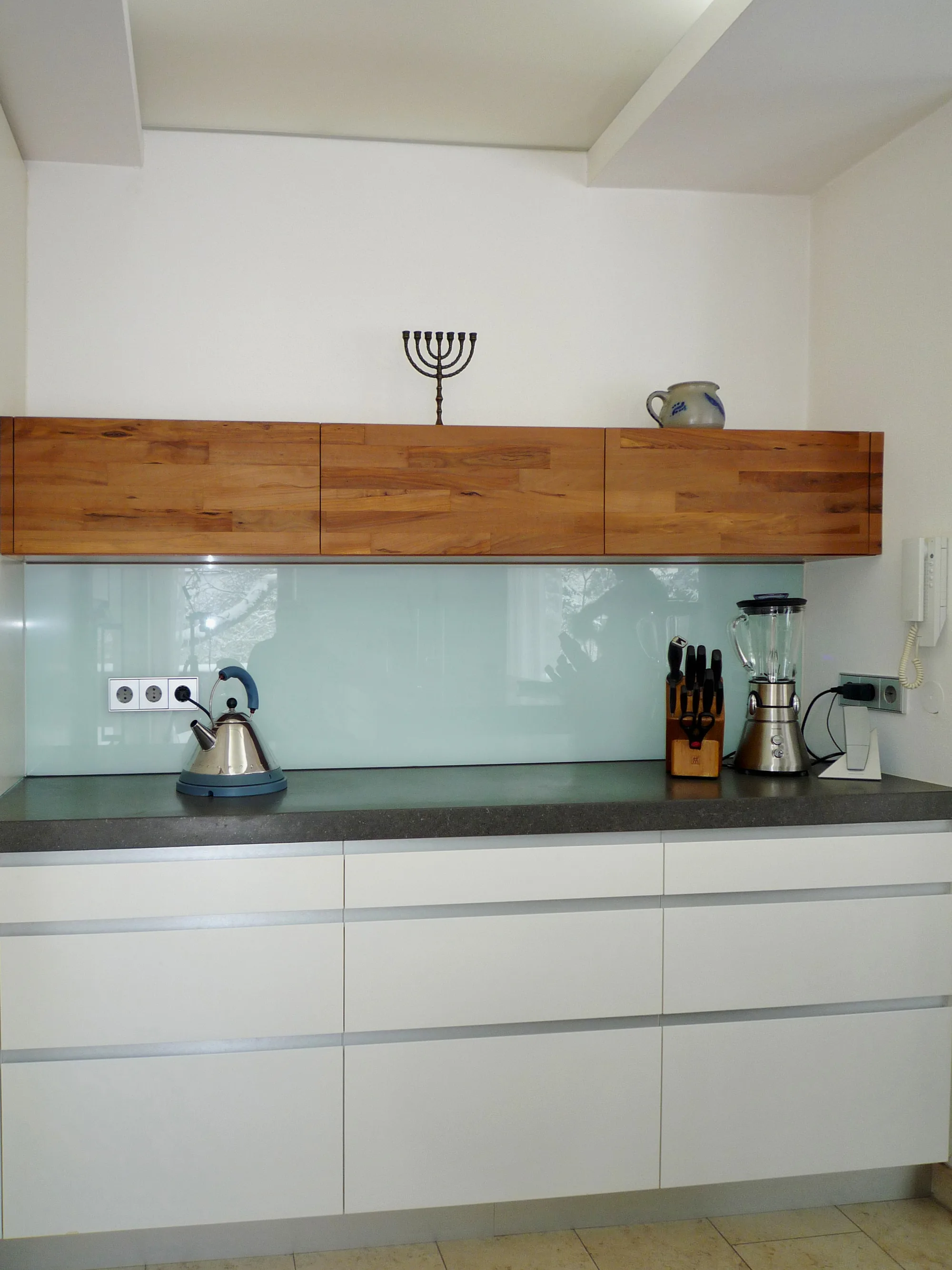Weiß matte Küchenzeile mit Altholz-Hängeschrank, Glasrückwand und Beton-Arbeitsplatte — Miller Küchen
