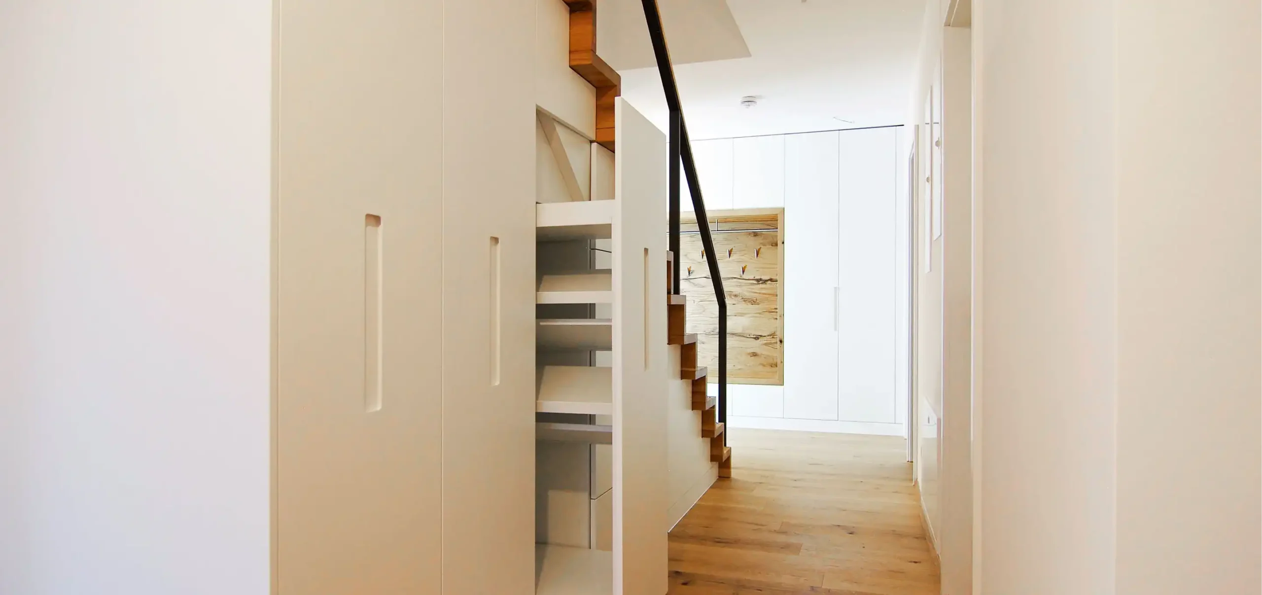 Flur mit Treppe und grifflosen Eiche-Einbauschränken im Wohnungsausbau — Miller Küchen